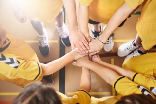 Ein Jugendteam jubelt gemeinsam in einer Turnhalle.